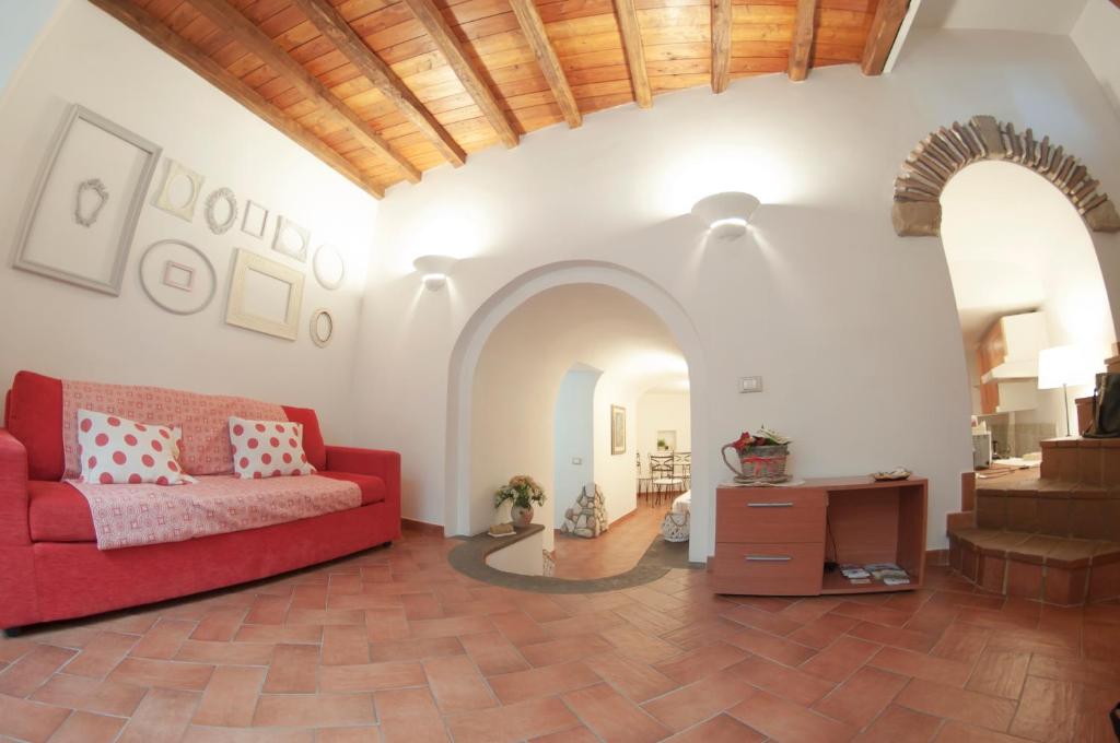 福尔梅洛Il Rosciolo Sulla Francigena的客厅配有红色的沙发和桌子