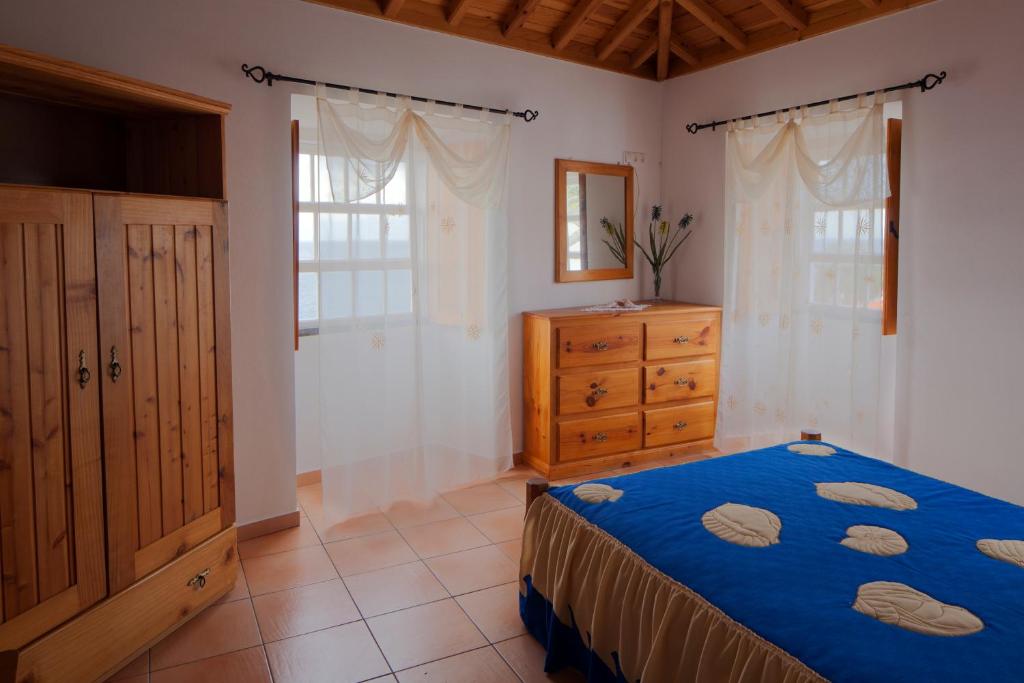 ManadasCasa do Zé - AL的一间卧室配有蓝色的床和木制梳妆台