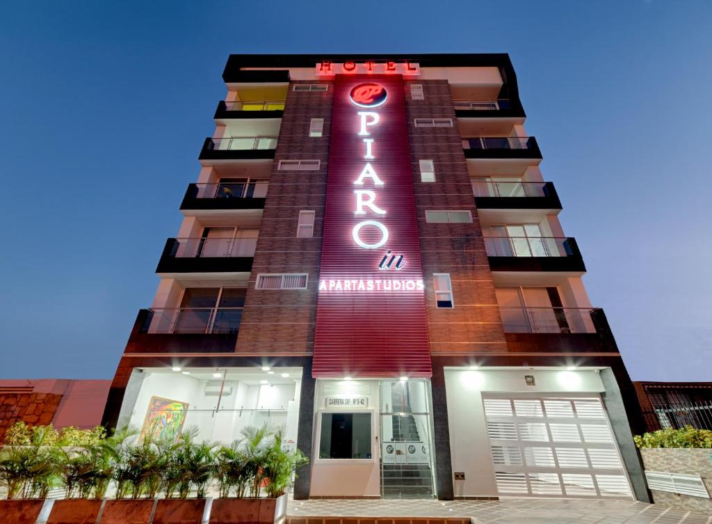 卡利Hotel Piaro In Suites的上面有红色 ⁇ 虹灯标志的高楼