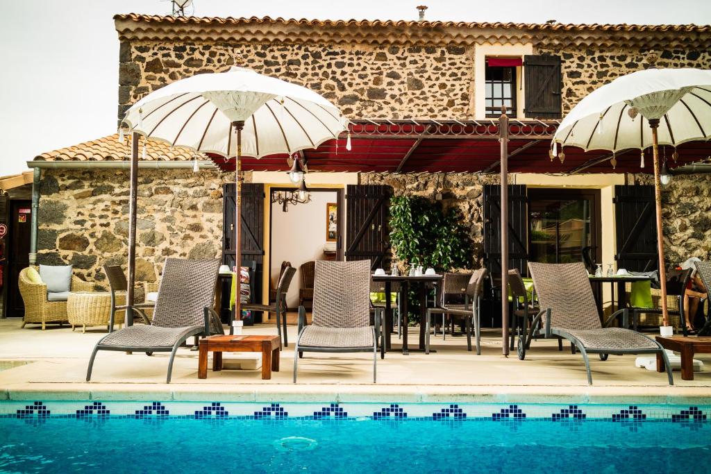 阿格德角贝日里卡普酒店的游泳池旁带椅子和遮阳伞的天井