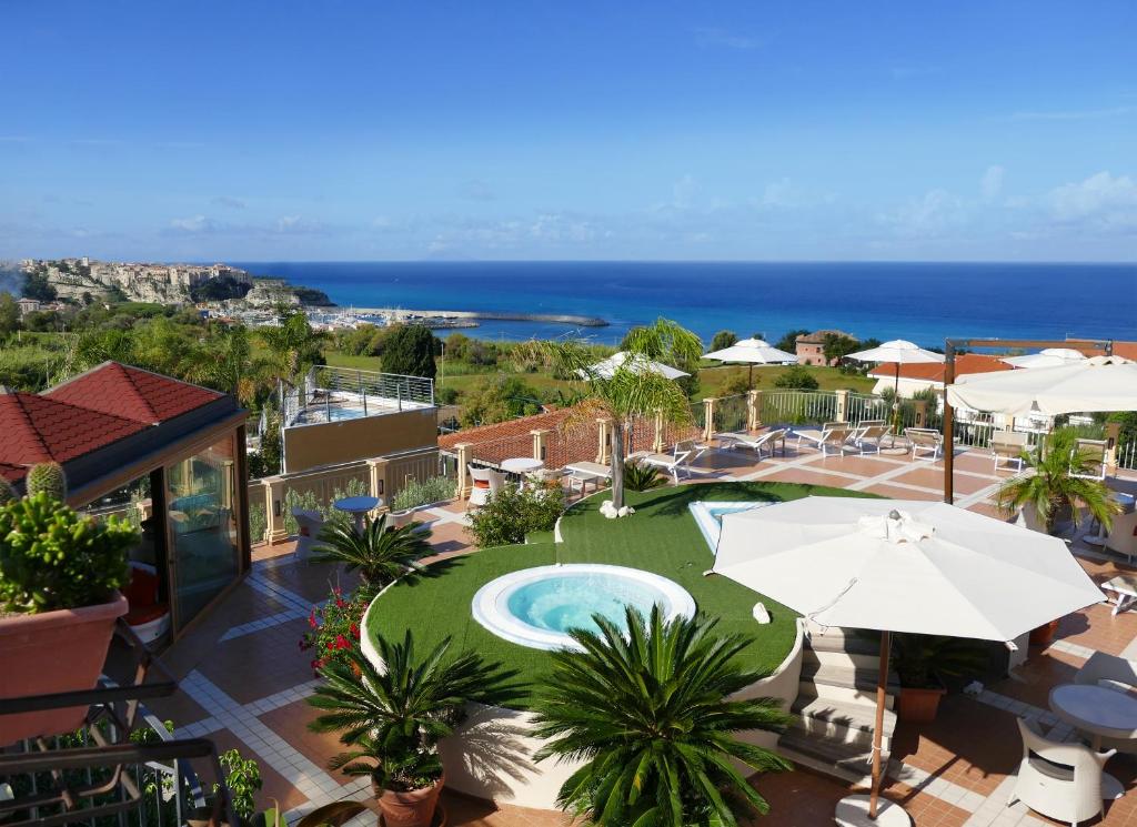 帕尔盖利亚Hotel Residence Piccolo的享有带游泳池和遮阳伞的度假村景致