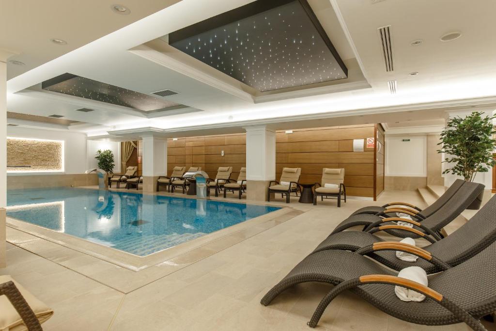 上维谢乌加布里埃拉酒店的游泳池位于酒店客房内,配有桌椅