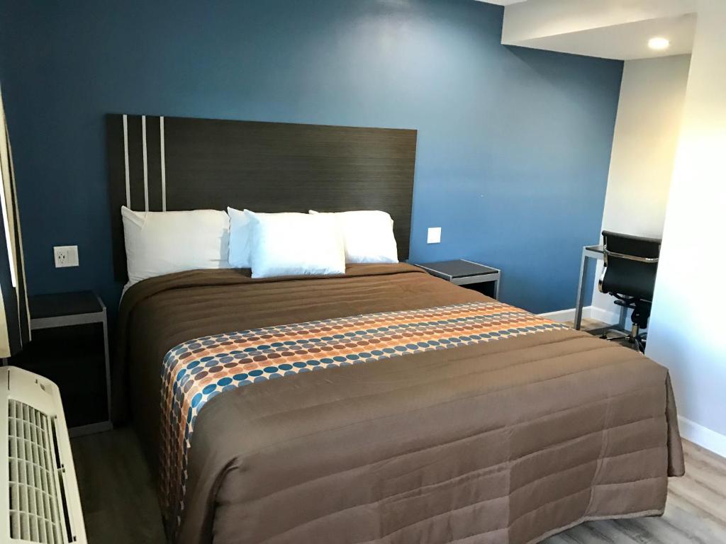 洛杉矶帝国汽车旅馆的一间卧室配有一张带蓝色墙壁的大床