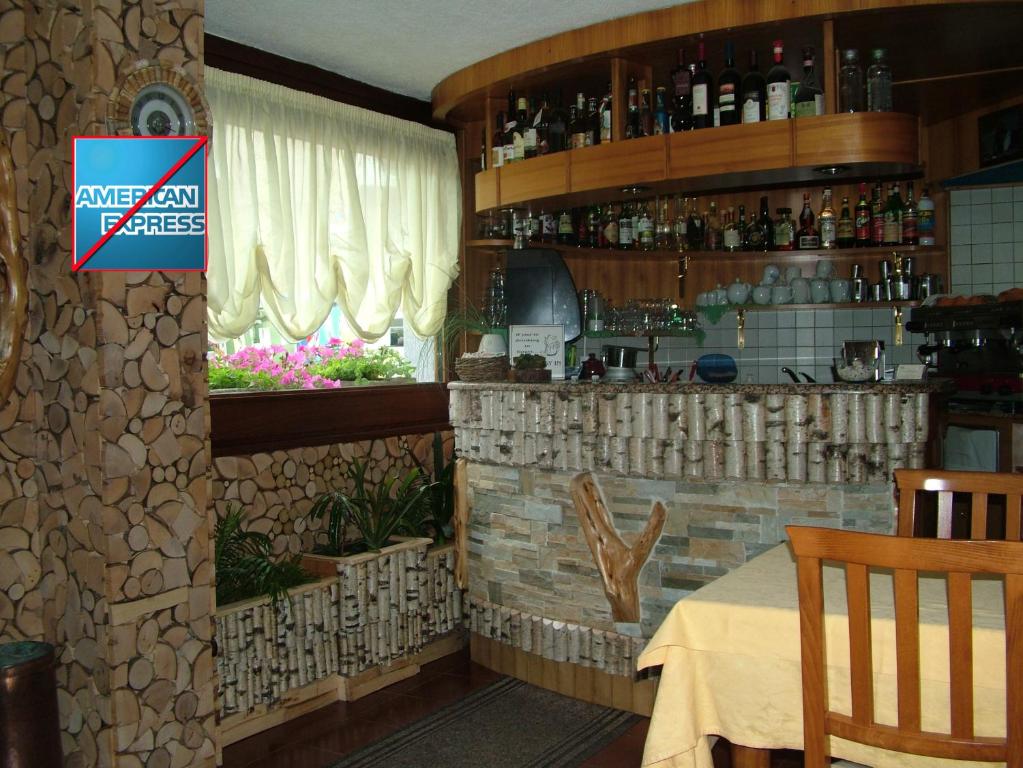 利莫内皮埃蒙特玛格瑞丝酒店的餐厅设有酒吧、桌子和窗户