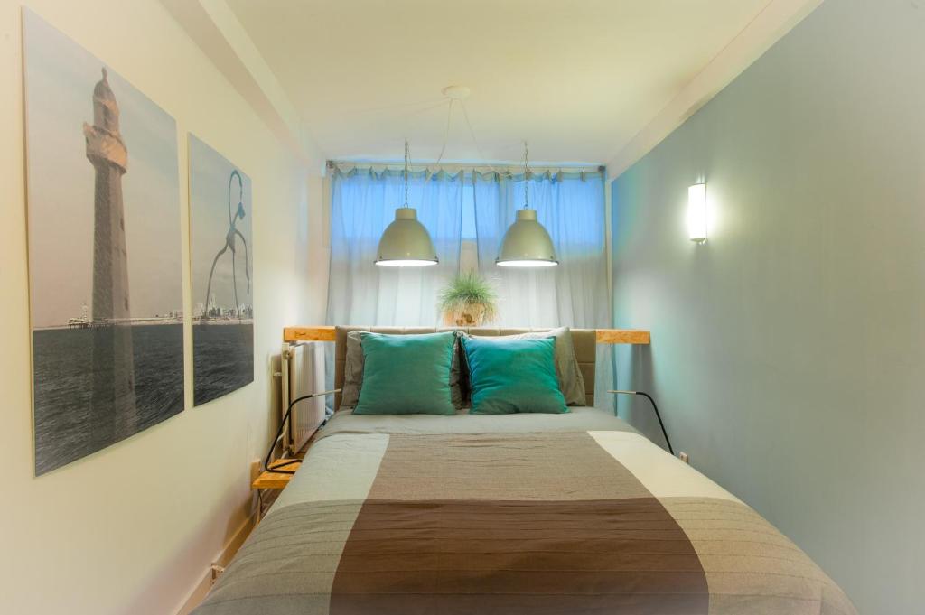 斯海弗宁恩Bluebeach Scheveningen的一间卧室配有一张带蓝色枕头的大床