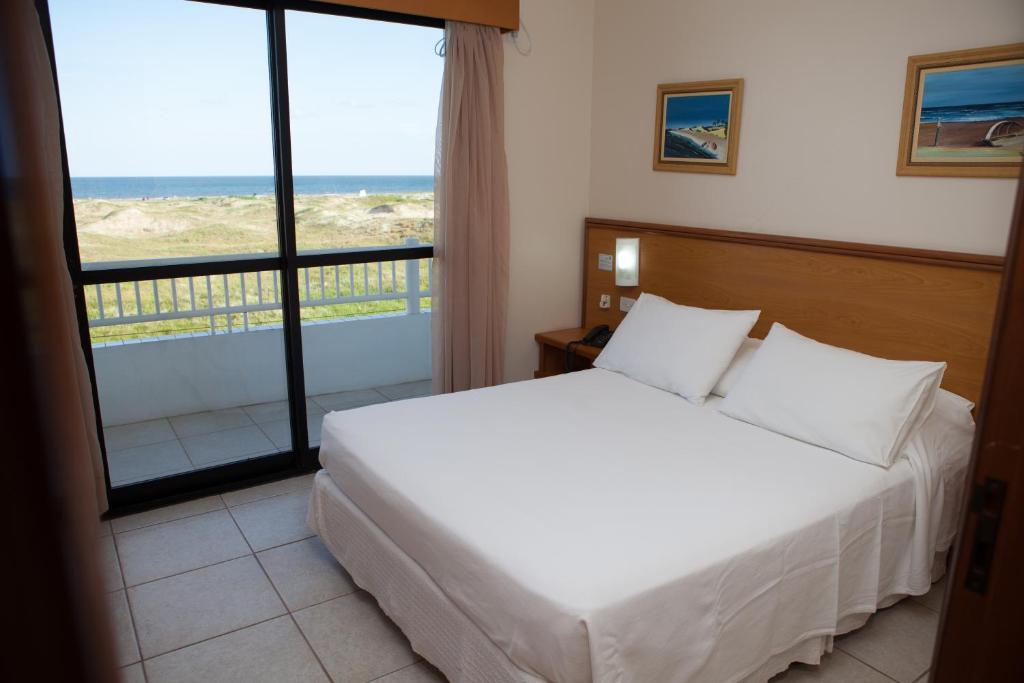卡西诺尼尔森海滩酒店的一间卧室配有一张床,享有海景