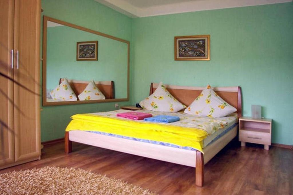 扎波罗热Apartment on Sobornyi Avenue的一间卧室配有一张带黄色床单和镜子的床