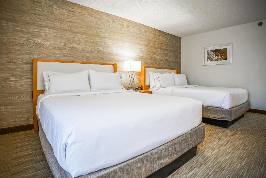 孟菲斯Sleep Inn & Suites的配有白色床单的酒店客房内的两张床