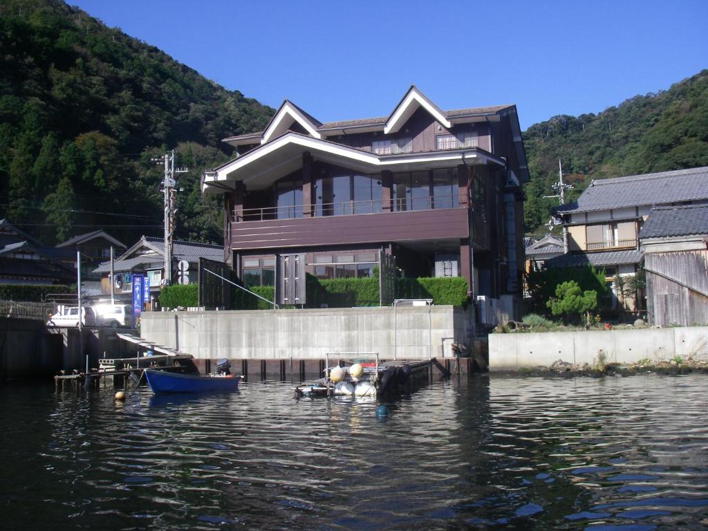 若狭町湖上館パムコ的水面上的房子,水面上有船