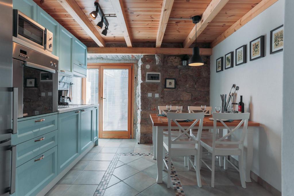 萨利Charming old stone house的厨房配有蓝色橱柜和桌椅