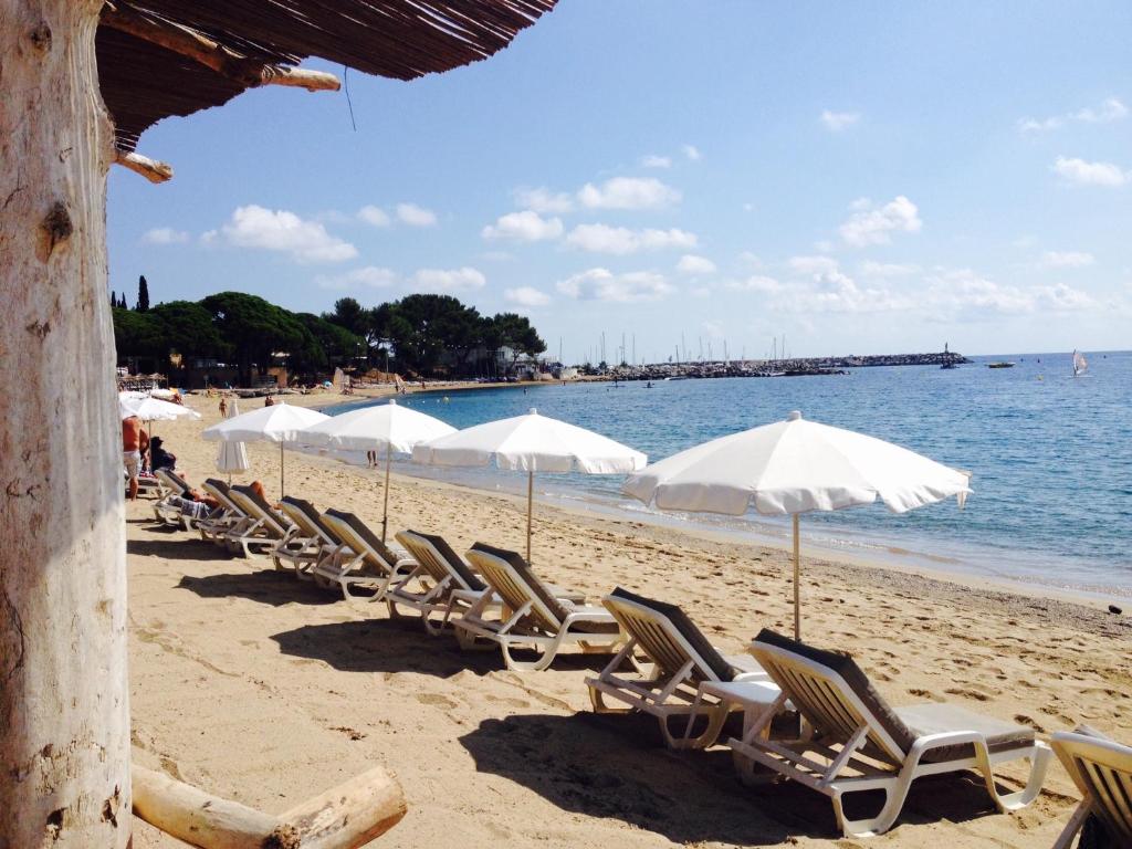 圣马克西姆卡萨米亚酒店的海滩上的一排椅子和遮阳伞