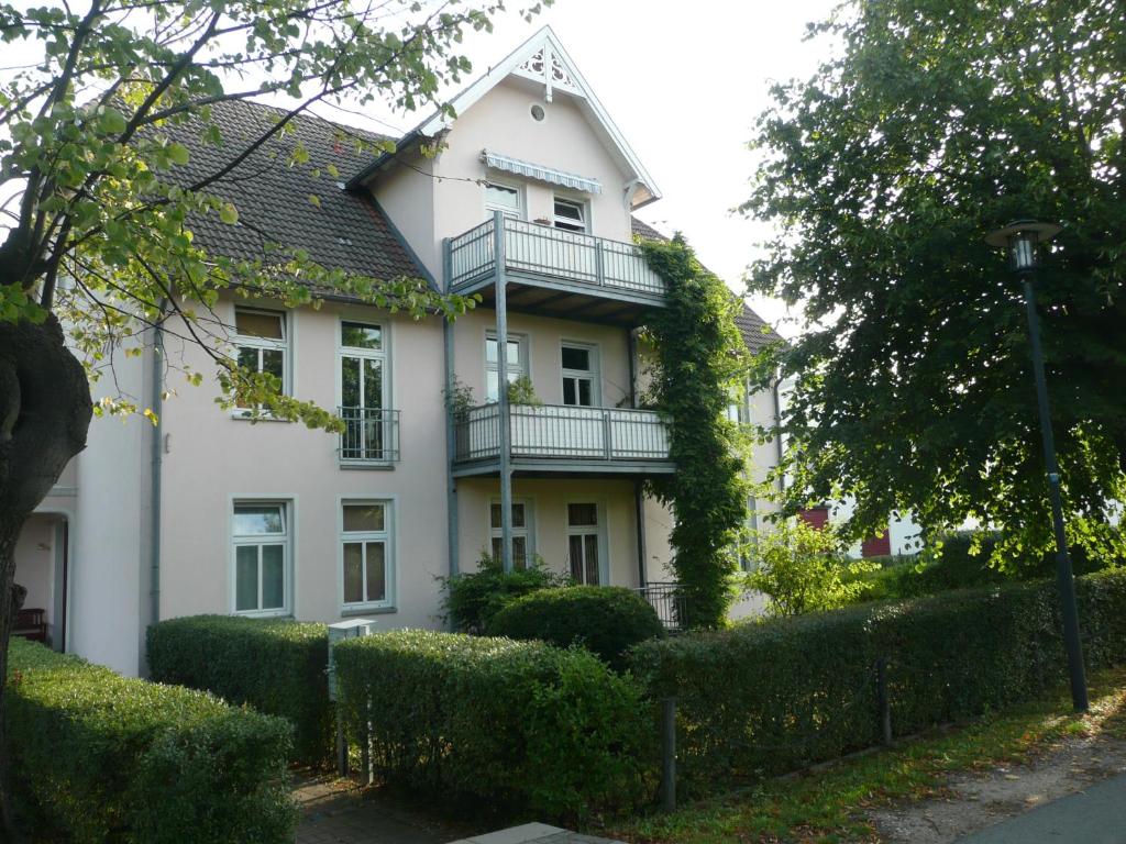 奥斯赛拜-屈隆斯博恩Ferienwohnung Am Molli Nr. 1的白色的房子,上面设有阳台