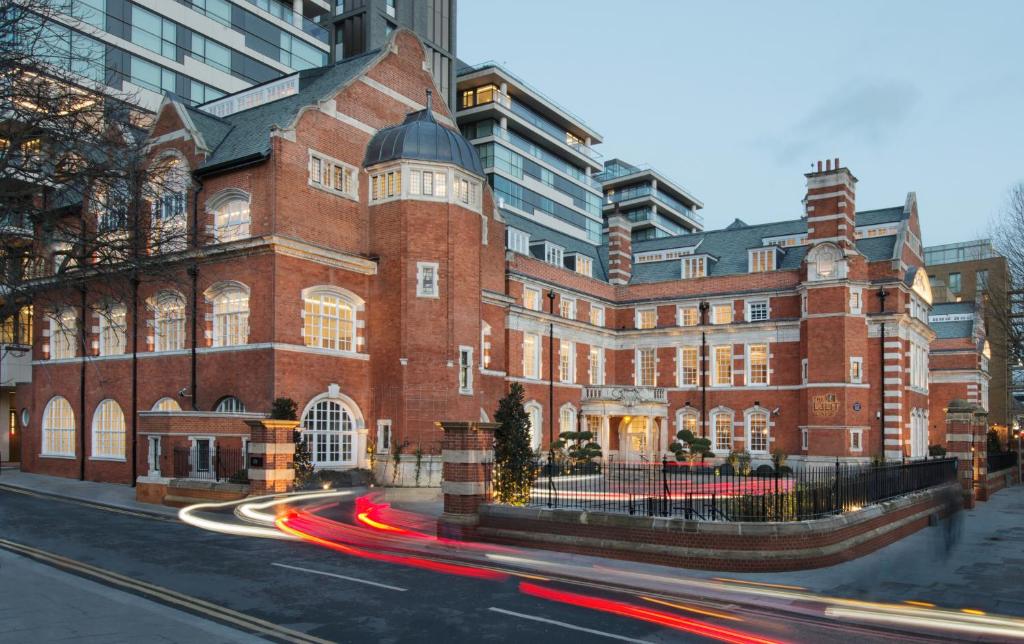 伦敦The LaLit London - Small Luxury Hotel of the World的前面有交通的一座大型红砖建筑