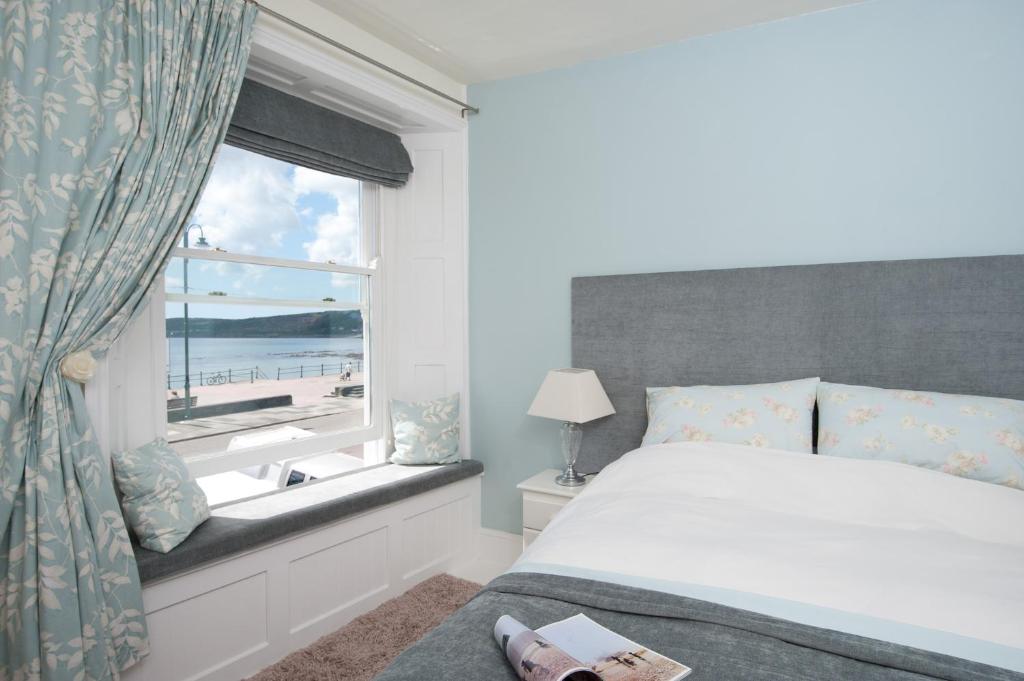 彭赞斯Sophia's的一间卧室设有一张床和一个享有海滩美景的窗户。