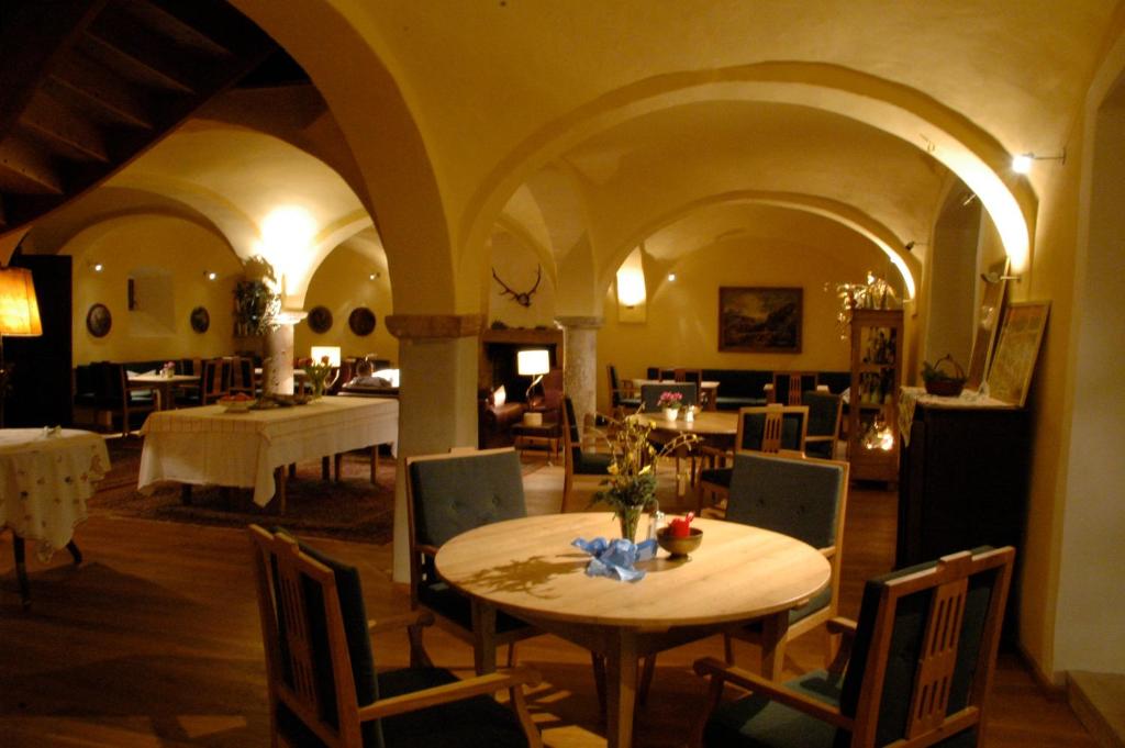多瑙河畔诺伊堡Pilgerhaus Bergen的一间带桌椅的用餐室和一间带桌子的房间
