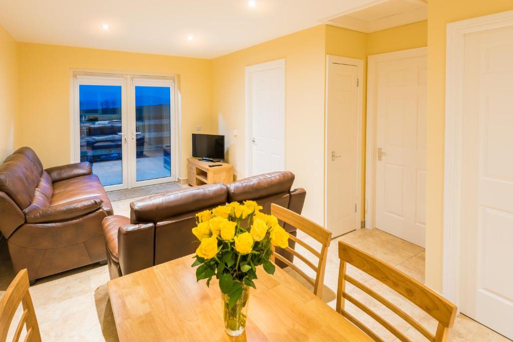 伦敦德里Elagh Cottages的客厅配有黄色鲜花的桌子