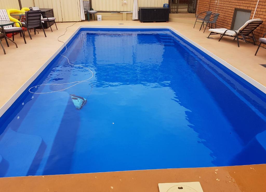 莱克斯恩特伦斯特拉普林斯度假屋的一个带桌椅的蓝色游泳池