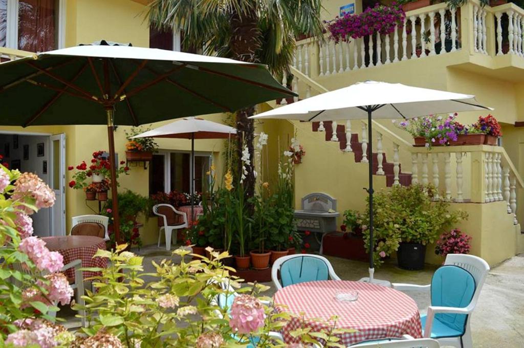 莫斯塔尔大卫旅馆的一个带桌椅、遮阳伞和鲜花的庭院