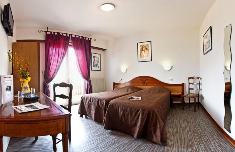 Eschbach-au-Val奥博索尔伯格旅馆的一间卧室配有一张床、一张桌子和一张桌子