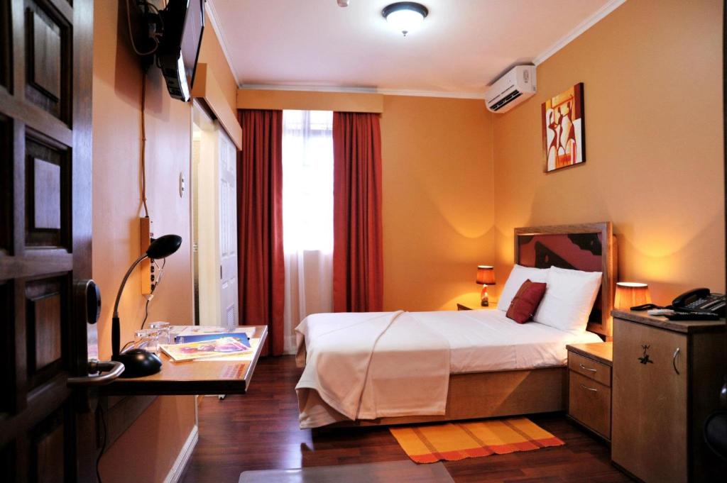 西班牙港Culture Crossroads Inn的酒店客房设有床和窗户。
