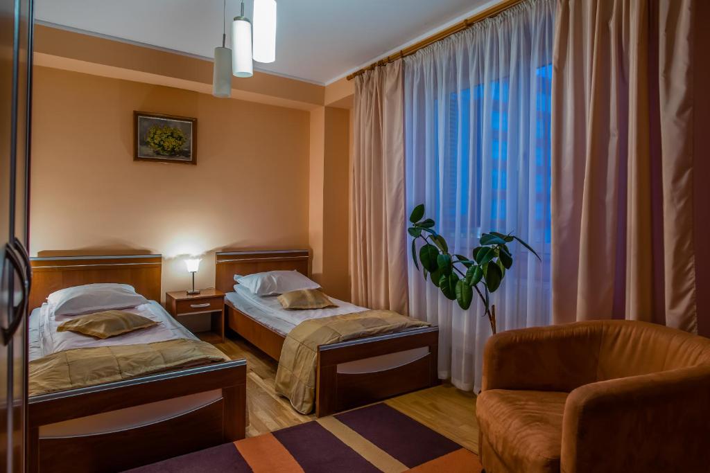 勒德乌齐Hotel Maria的酒店客房设有两张床和窗户。