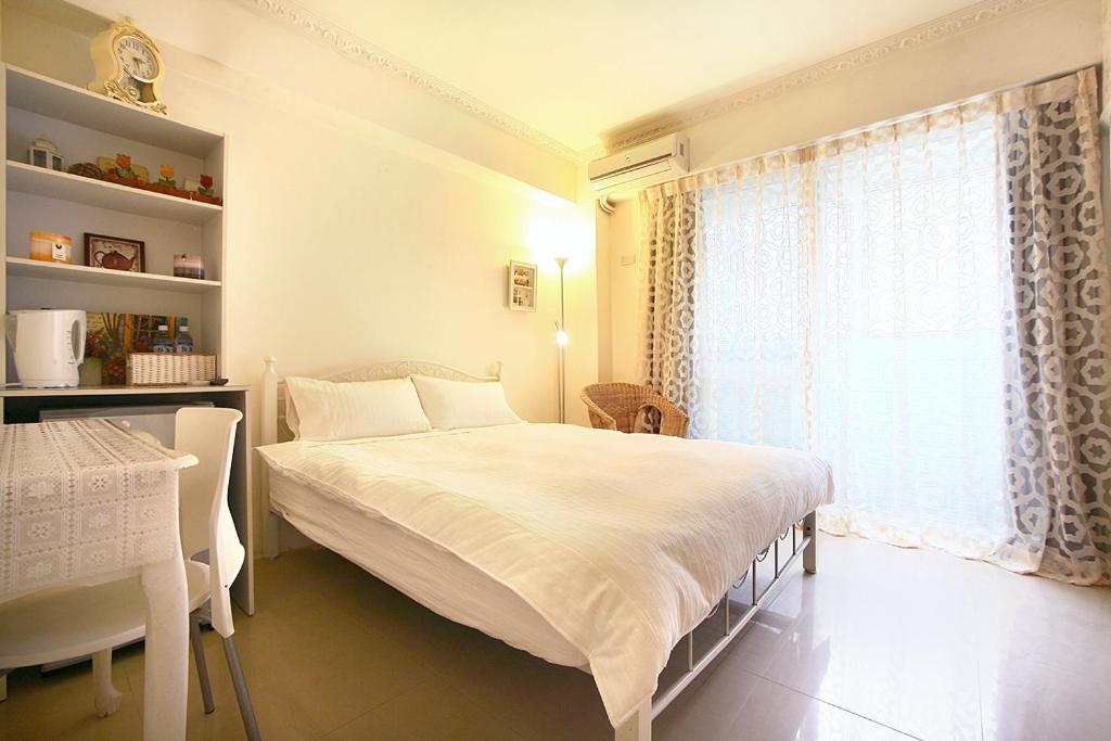 台中市RaRa 旅宿的卧室配有白色的床和窗户。
