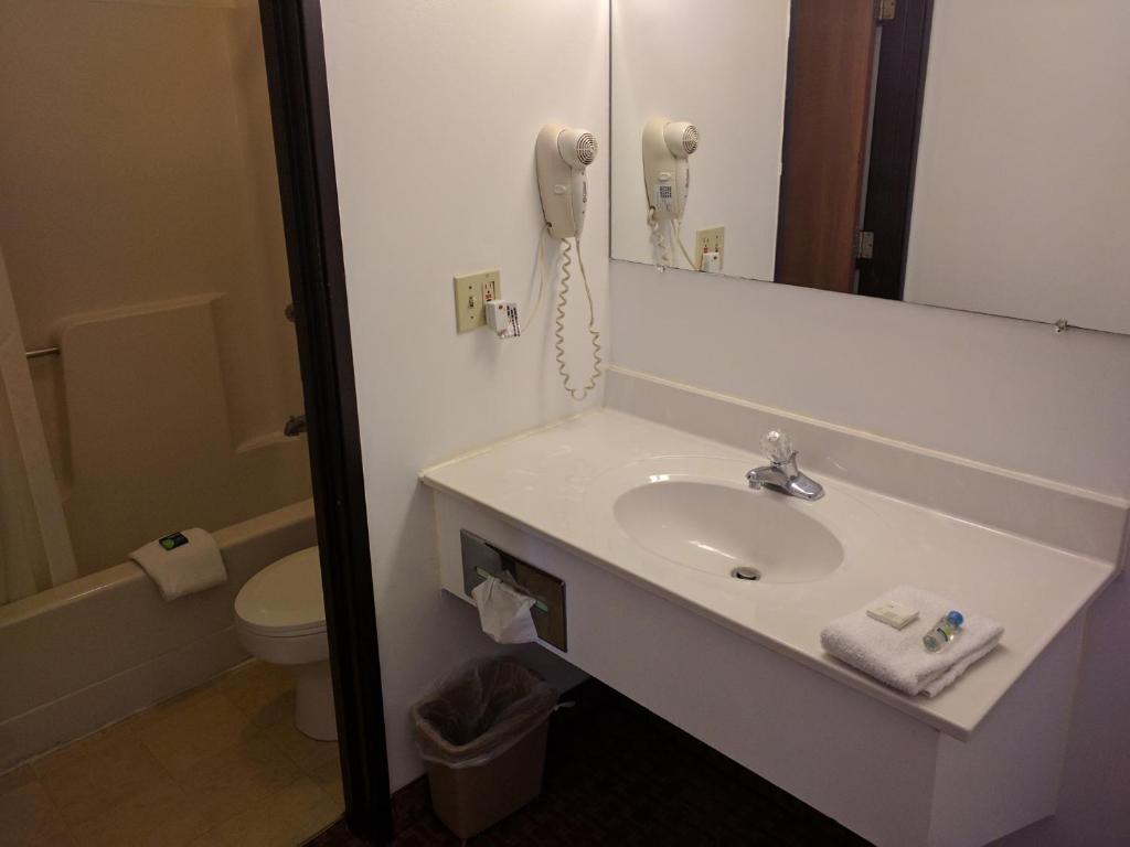 Valley Green哈里斯堡-纽克超值汽车旅馆的一间带水槽的浴室和墙上的一部电话