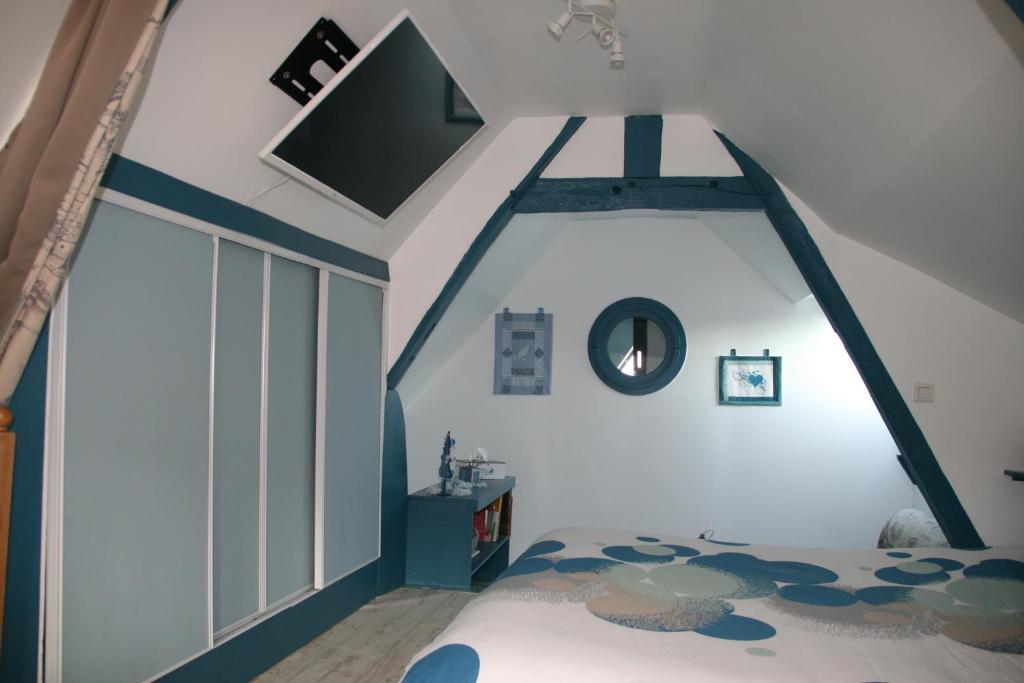 Fontaine-LavaganneGîte à la Ferme des Rooses的一间卧室设有一张床,天花板上配有电视。