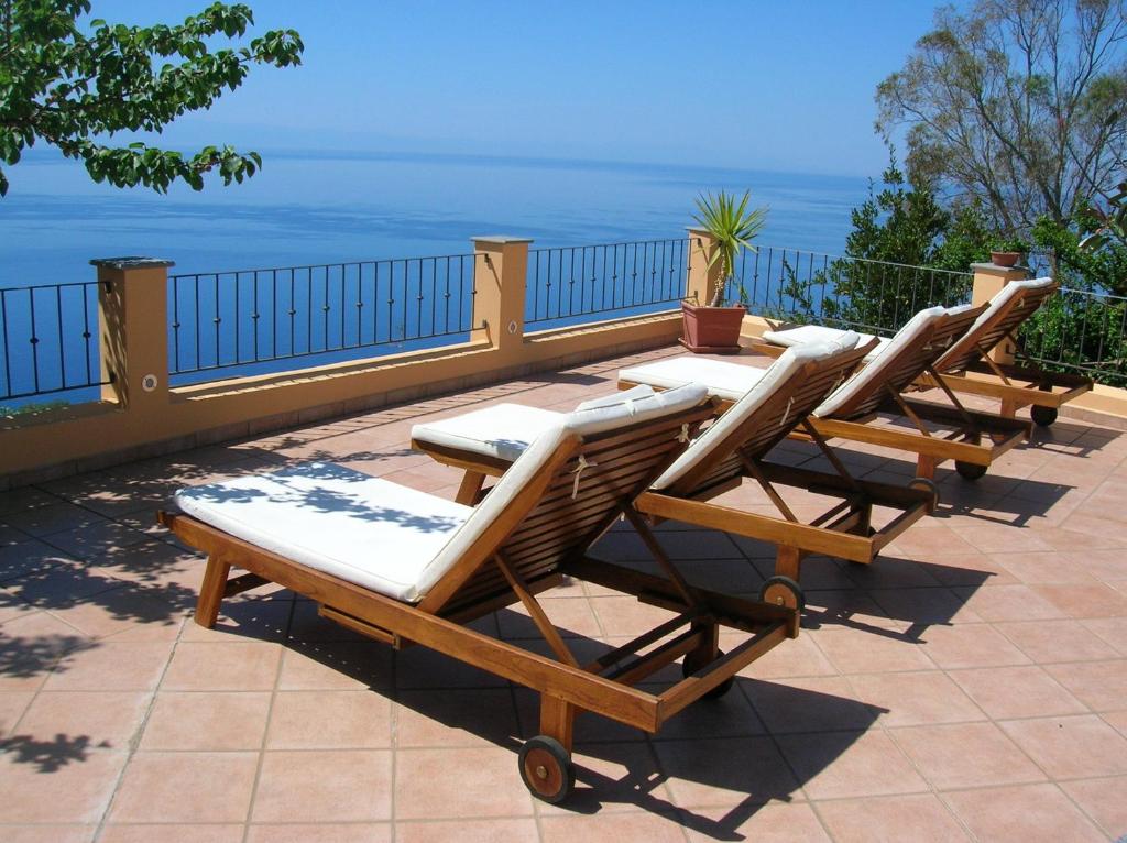 雷妮Resort Al Belvedere Salina的坐在庭院里的一排躺椅