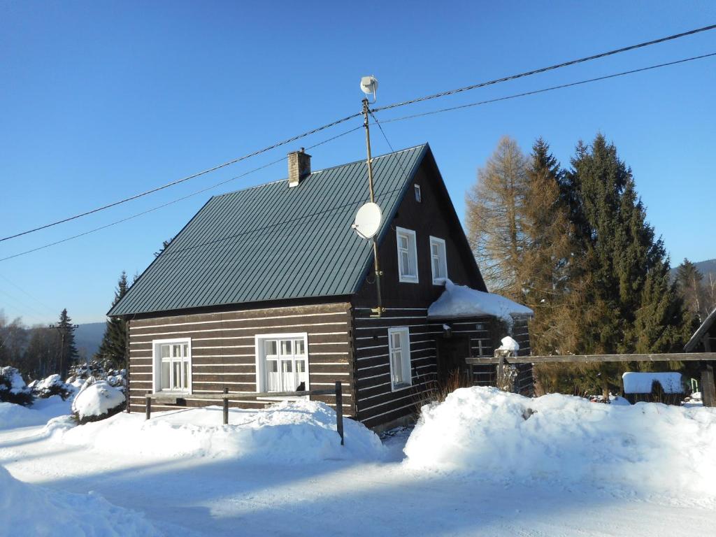 Nové HamryChata Pilka的小木屋前面有雪
