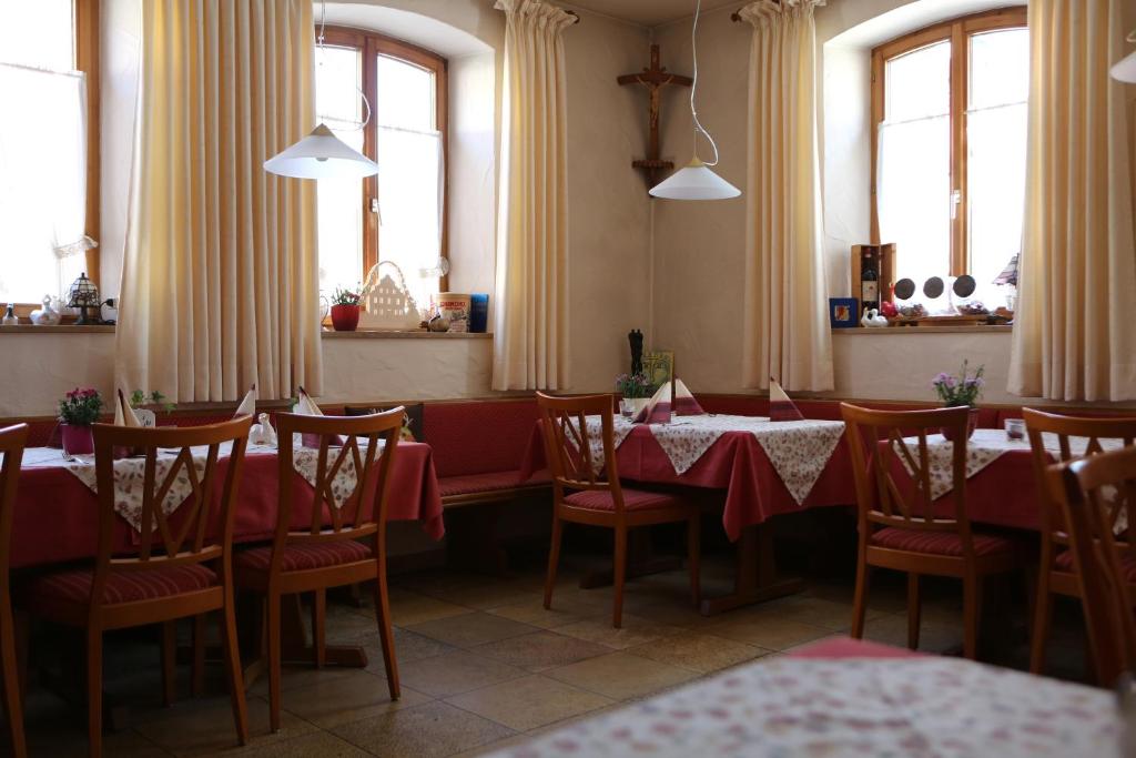 黑里登吉尼博尔利姆巴赫酒店的用餐室设有桌椅和窗户。