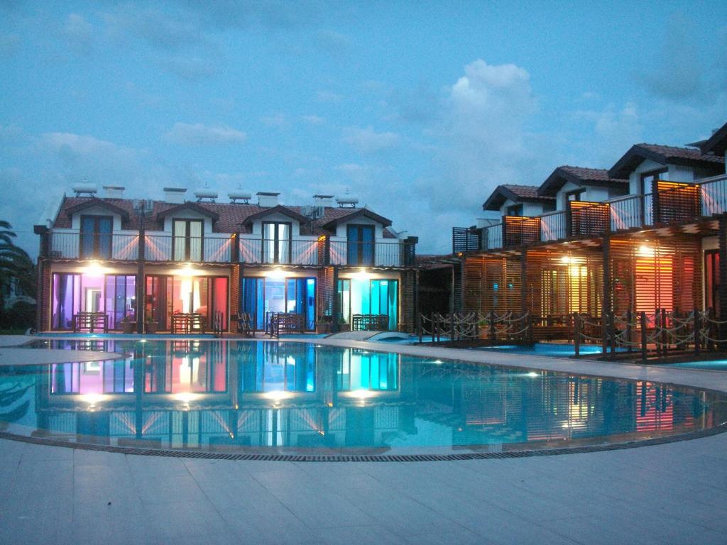 达利安Aydos Suites的夜间设有游泳池的酒店