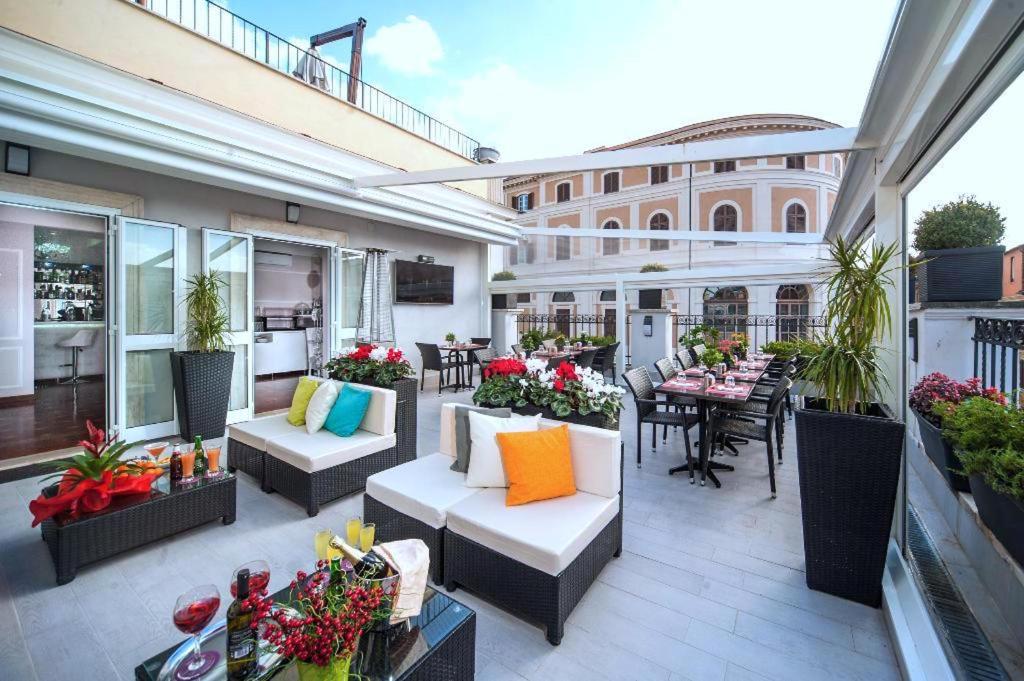 罗马Relais Trevi 95 Boutique Hotel的一个带沙发和桌子的户外庭院和一座建筑