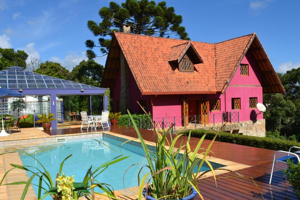 蒙特韦尔迪安娜特拉旅馆的一座带游泳池和粉红色房子的房子