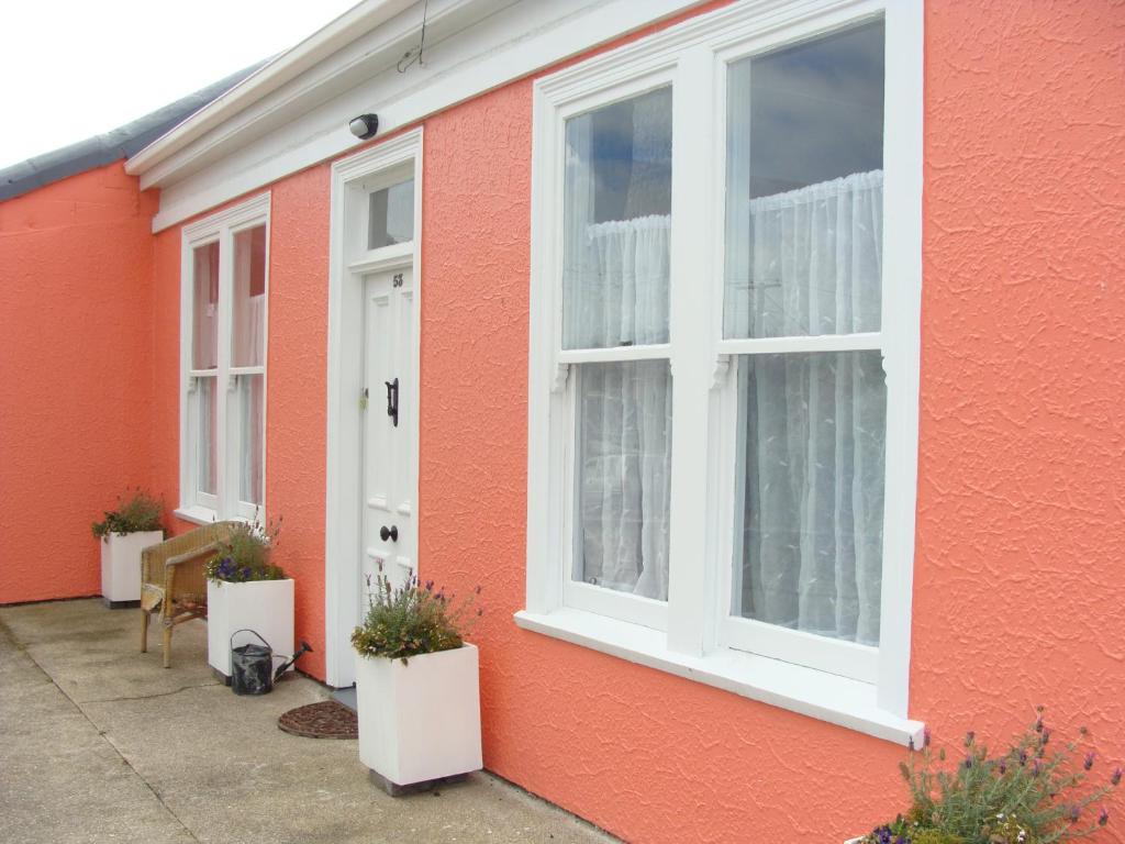 奥玛鲁奥马璐粉红色度假屋的红色的房子,有两个窗户和白色的门