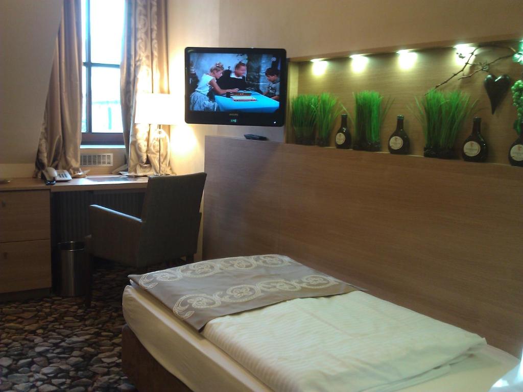 法伊茨赫夏伊姆葡萄酒餐厅&斯普德洛赫酒店的酒店客房设有一张床和墙上的电视