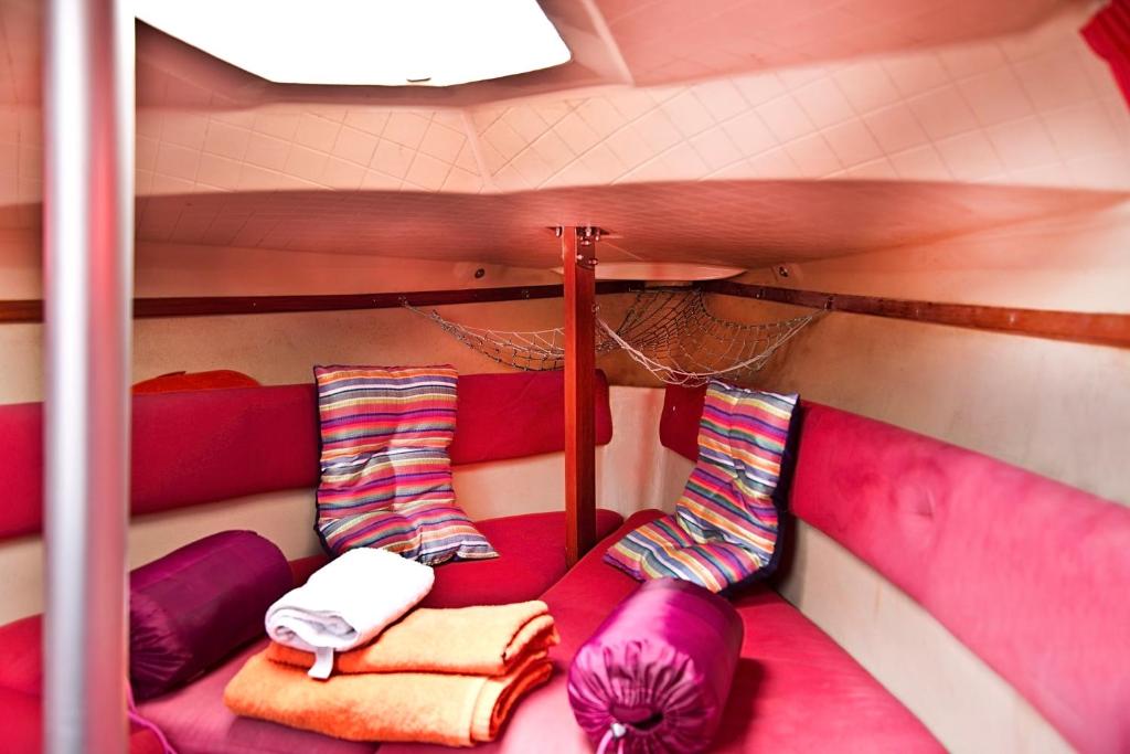 莱萨·达·帕尔梅拉VRS - Low Cost Beach Boat的紫色和粉色家具的客房内的一张床位