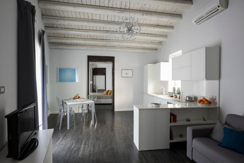 莫迪卡Casa Matteotti的白色的厨房和带桌子的客厅