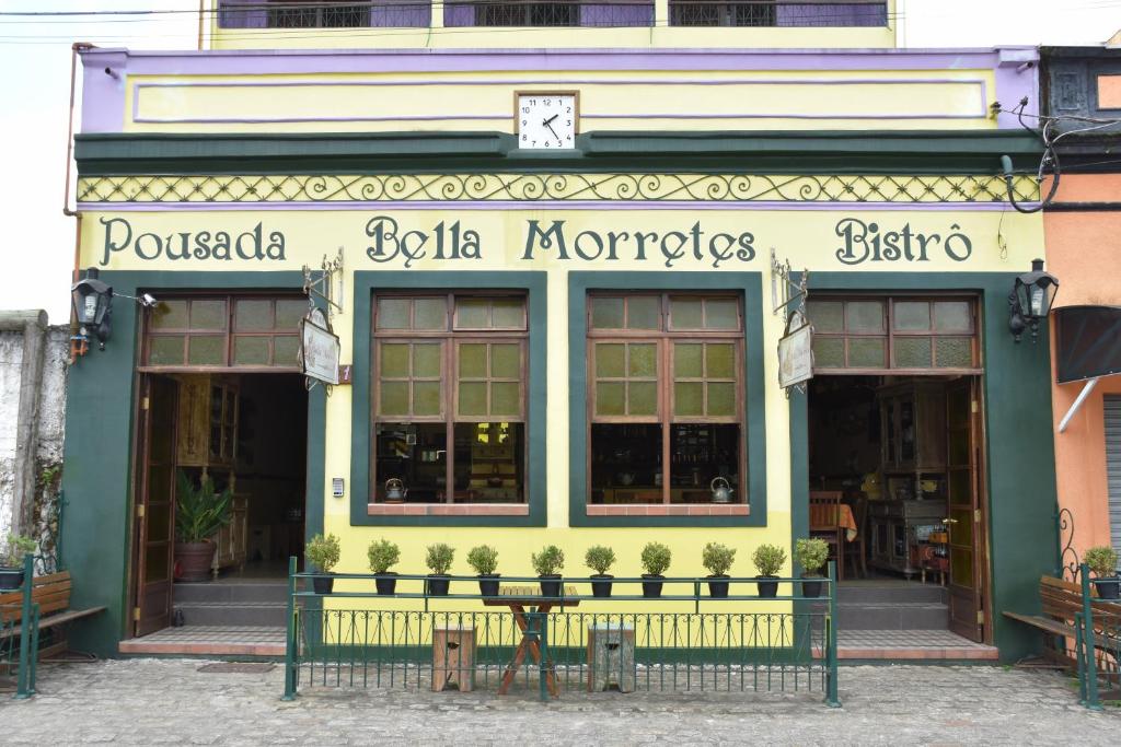 莫雷蒂斯Pousada Bella Morretes的前面的商店,前面有桌子
