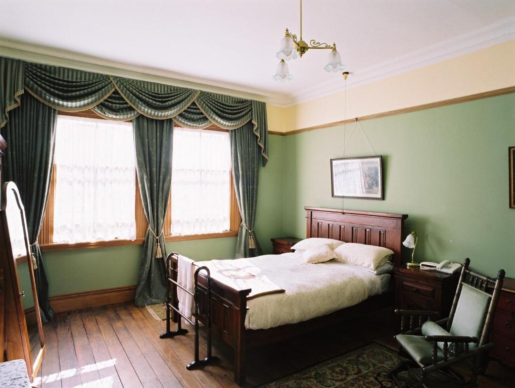 奥克兰布拉马尔议会大厦住所加早餐旅馆的一间卧室设有一张带绿色墙壁和窗户的床。