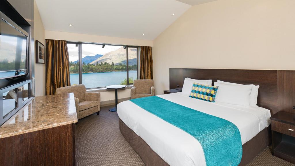 皇后镇皇后镇湖畔国敦度假酒店的酒店客房设有一张床和一个大窗户
