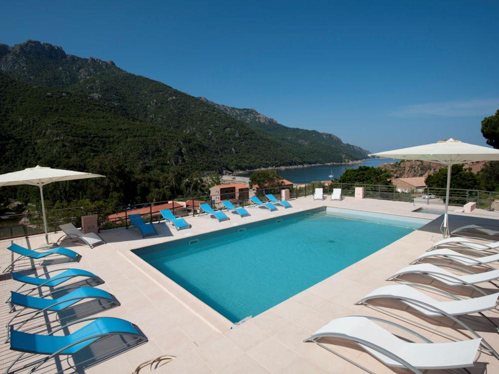 波尔图Villa Kalliste的一个带椅子和遮阳伞的游泳池
