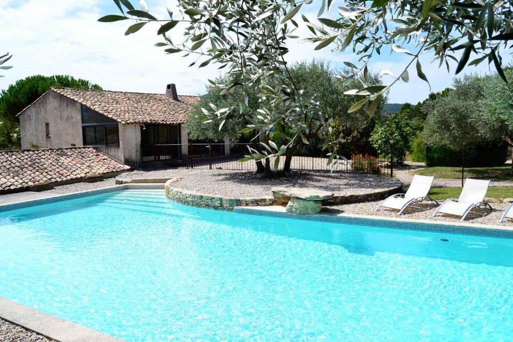 Entrechaux达纳斯旅馆的一个带椅子的游泳池以及一座房子
