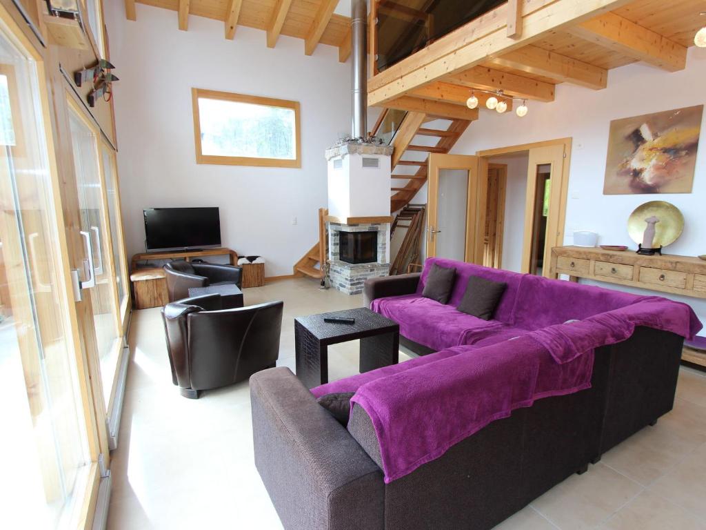 拉茨欧马兹Charming chalet in La Tzoumaz with open fireplace的客厅配有紫色沙发和电视