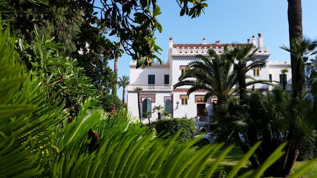 戛纳美丽海岸别墅旅馆的一座棕榈树掩映的白色房子