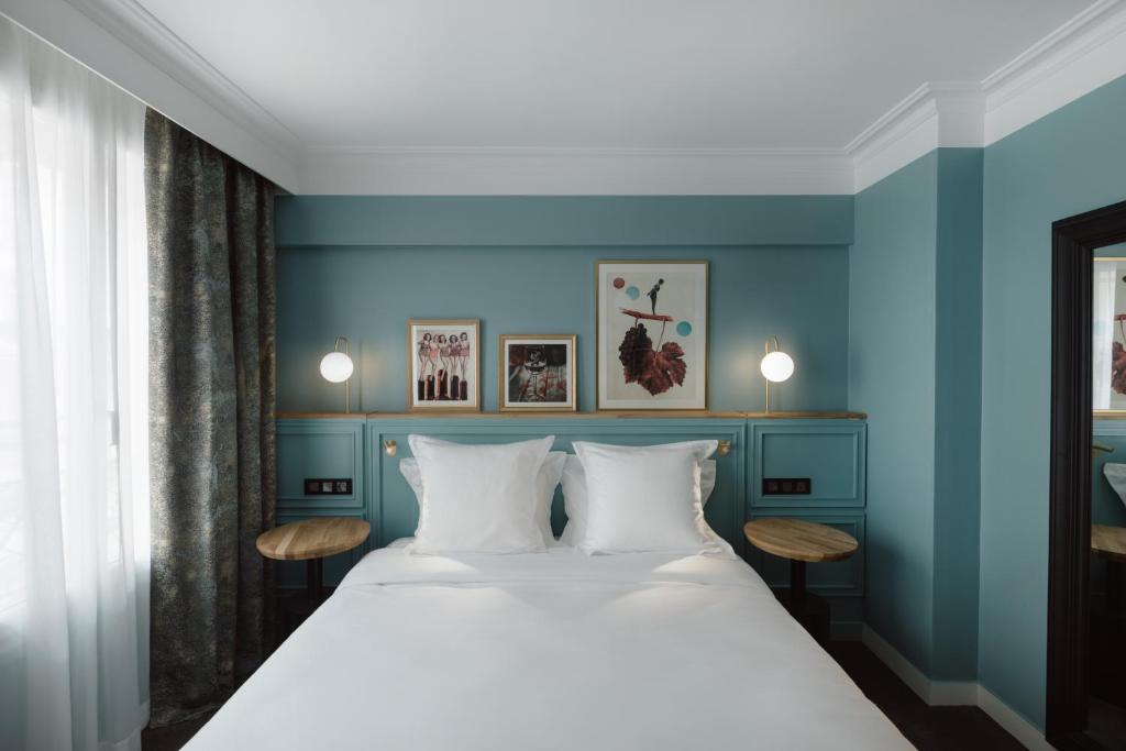 巴黎XO Hotel Paris的一间卧室配有一张带蓝色墙壁的大床