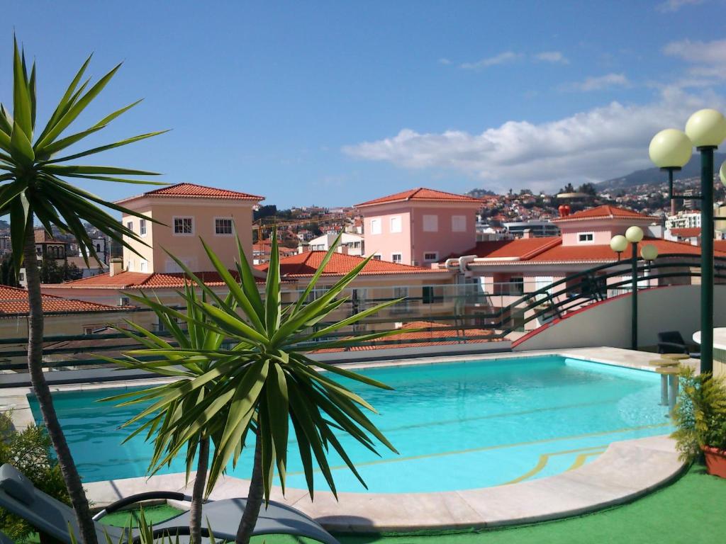 丰沙尔温莎酒店的棕榈树建筑顶部的游泳池