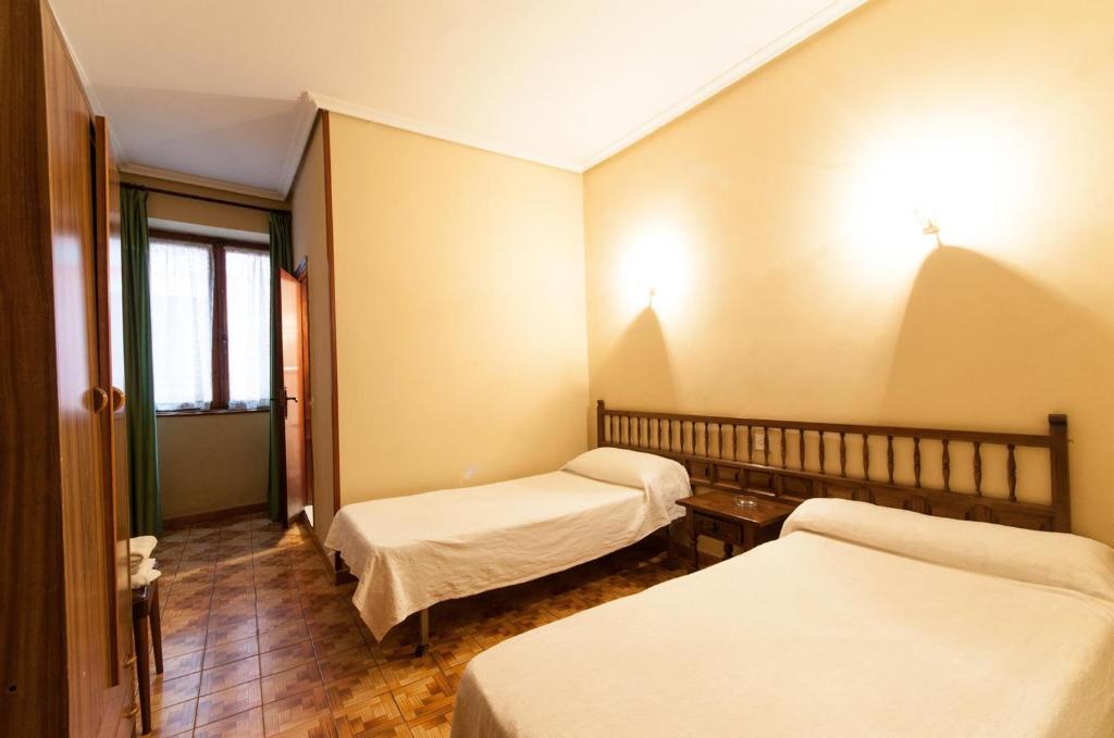利亚内斯伊比利亚旅馆的带三张床和窗户的客房