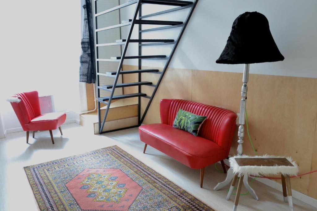 布达佩斯22号公寓的一间带红色椅子和楼梯的客厅