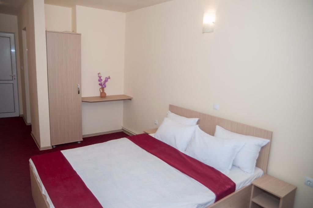 布拉索夫Dumbrava Minunata的一间卧室配有带白色床单和枕头的床。